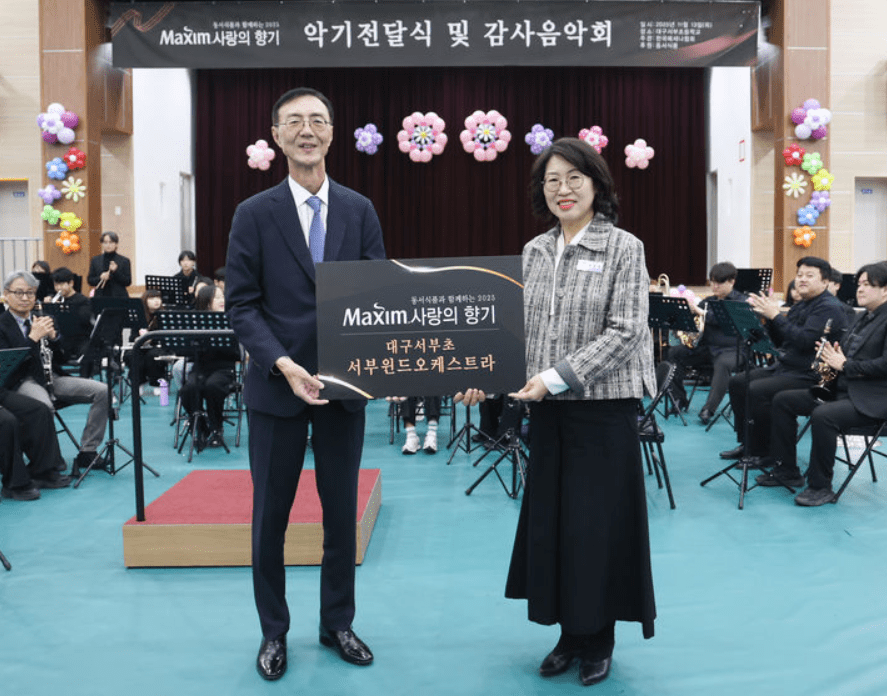 △ 최상인 동서식품 홍보상무(왼쪽)와 이보경 대구서부초등학교 교장이 지난 13일 열린 '제18회 맥심 사랑의 향기' 행사에서  기념촬영 하고 있다. (사진=동서식품)